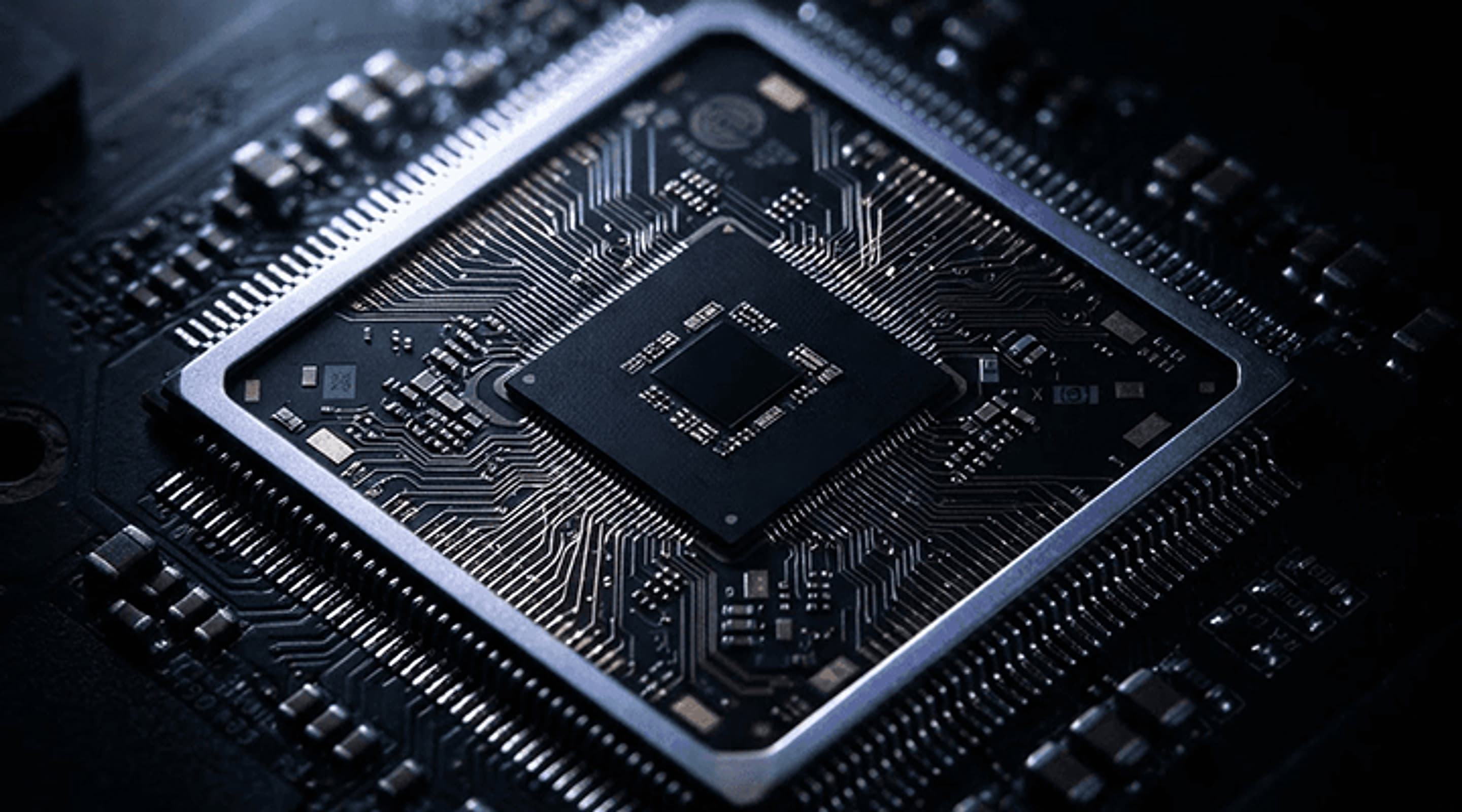 Close-up of a dark circuit board with a central chip package surrounded by fine traces and components